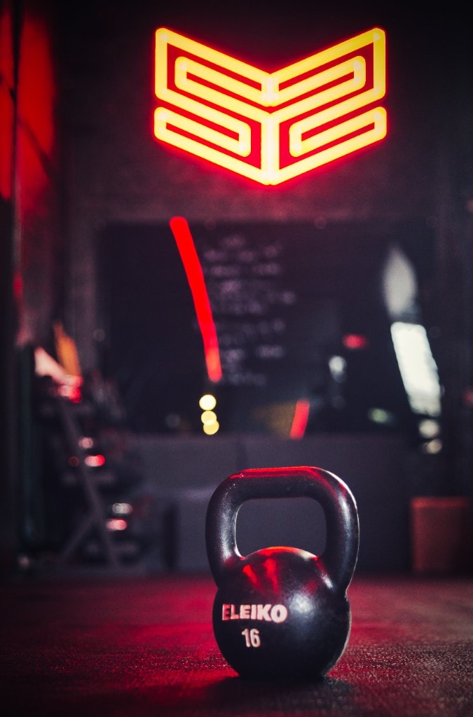 Kettlebell vor dem leuchtenden Signet